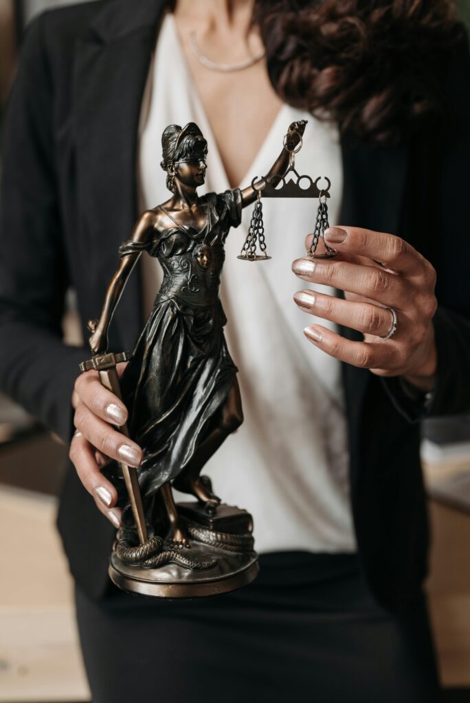 a woman holding a statue of justice